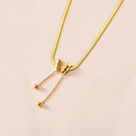 Gold necklace with a cat-shaped clasp on a beige background